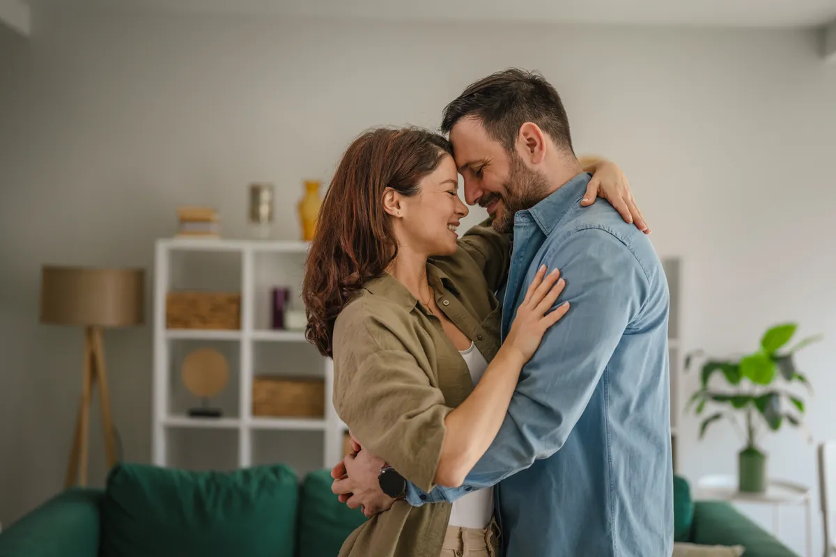Spirituális kapcsolatban élő pár ölelkezik a nappaliban.
