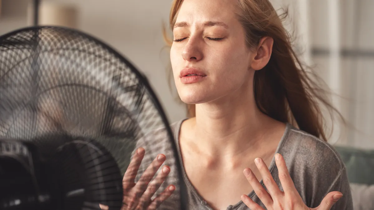Légkondi helyett ventilátort használó nő