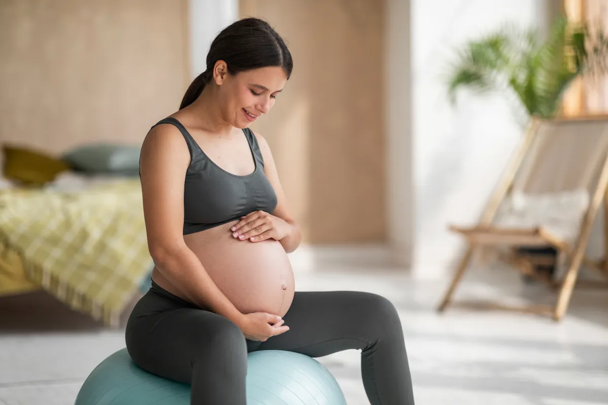 Fitneszlabdán ülő kismama, aki tudja, hogy lehet edzeni terhesség alatt is.