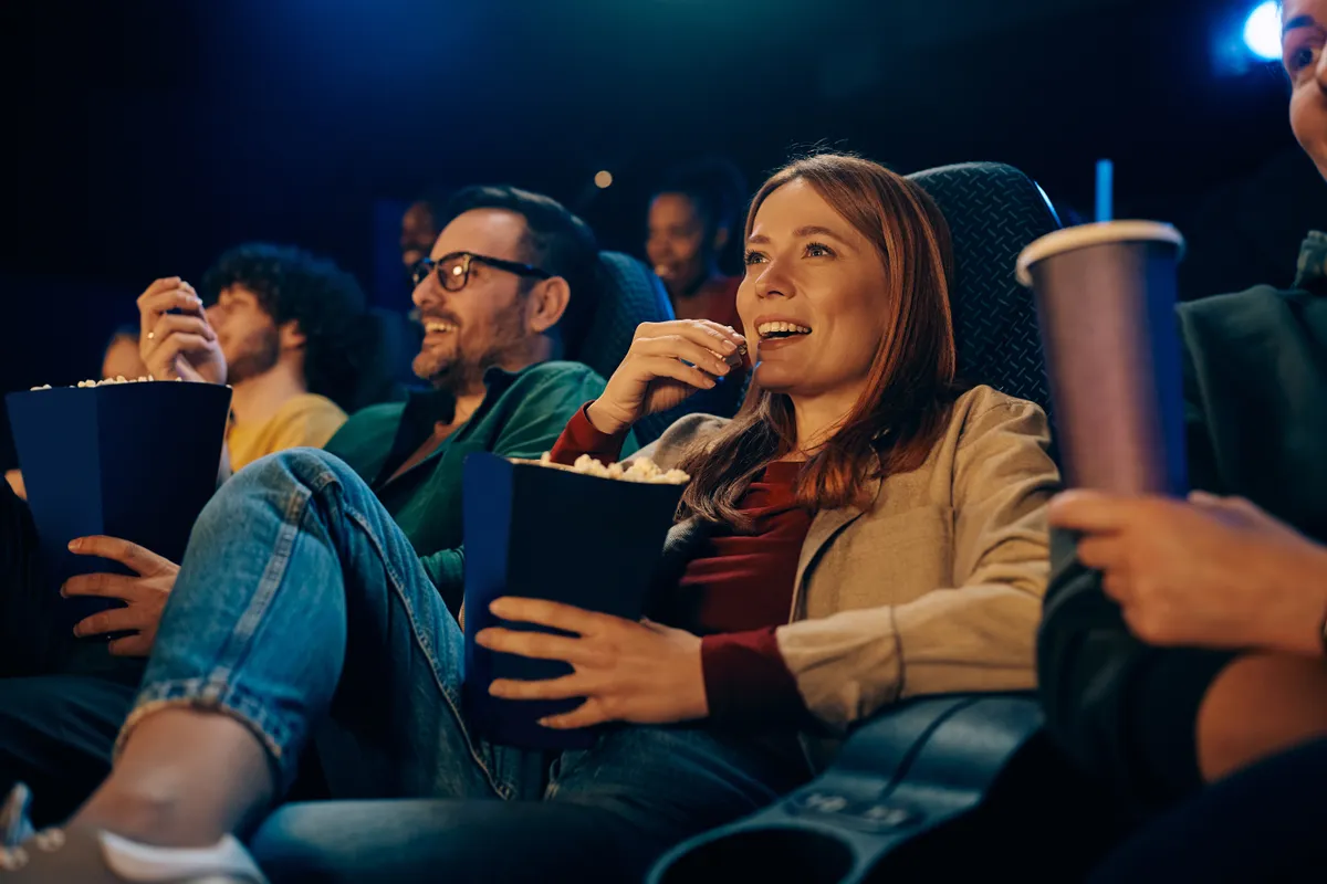 Egy nő a kvízben popcornt eszik a moziban.