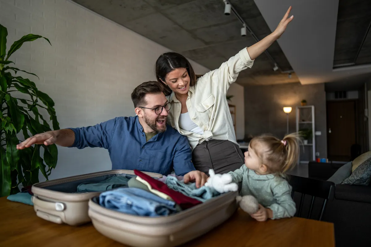 Family packing suitcase for vacation at home
