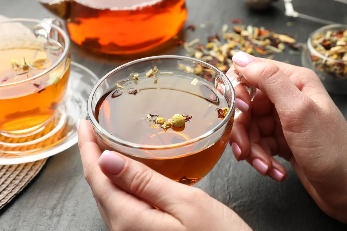 Woman,With,Aromatic,Herbal,Tea,At,Black,Table,,Closeup