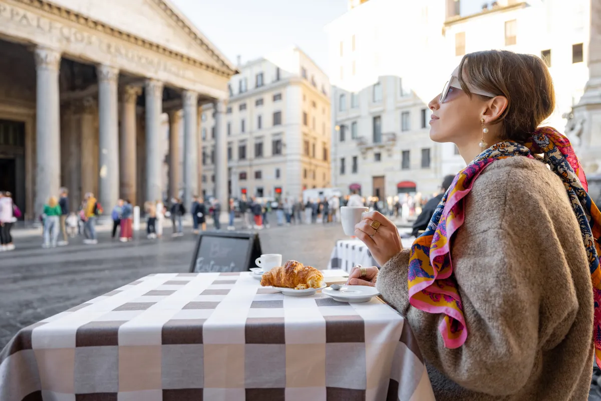 Woman,Having,Breakfast,With,Croissant,And,Coffee,At,Outdoor,Cafe