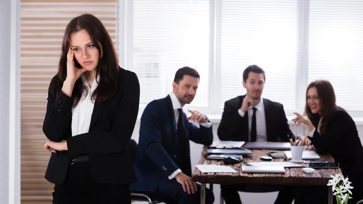 Portrait,Of,A,Sad,Businesswoman,In,Front,Of,Her,Colleagues