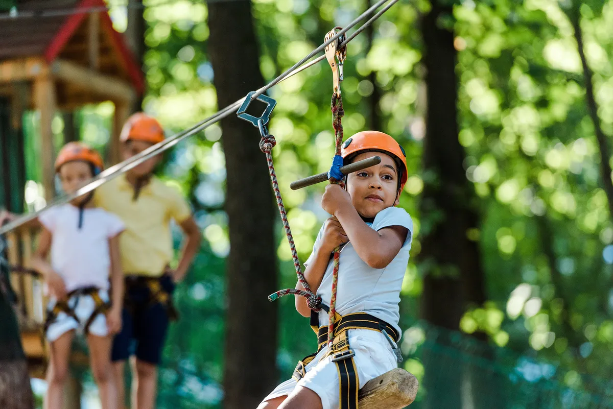 Kisgyerek egy zipline pályán