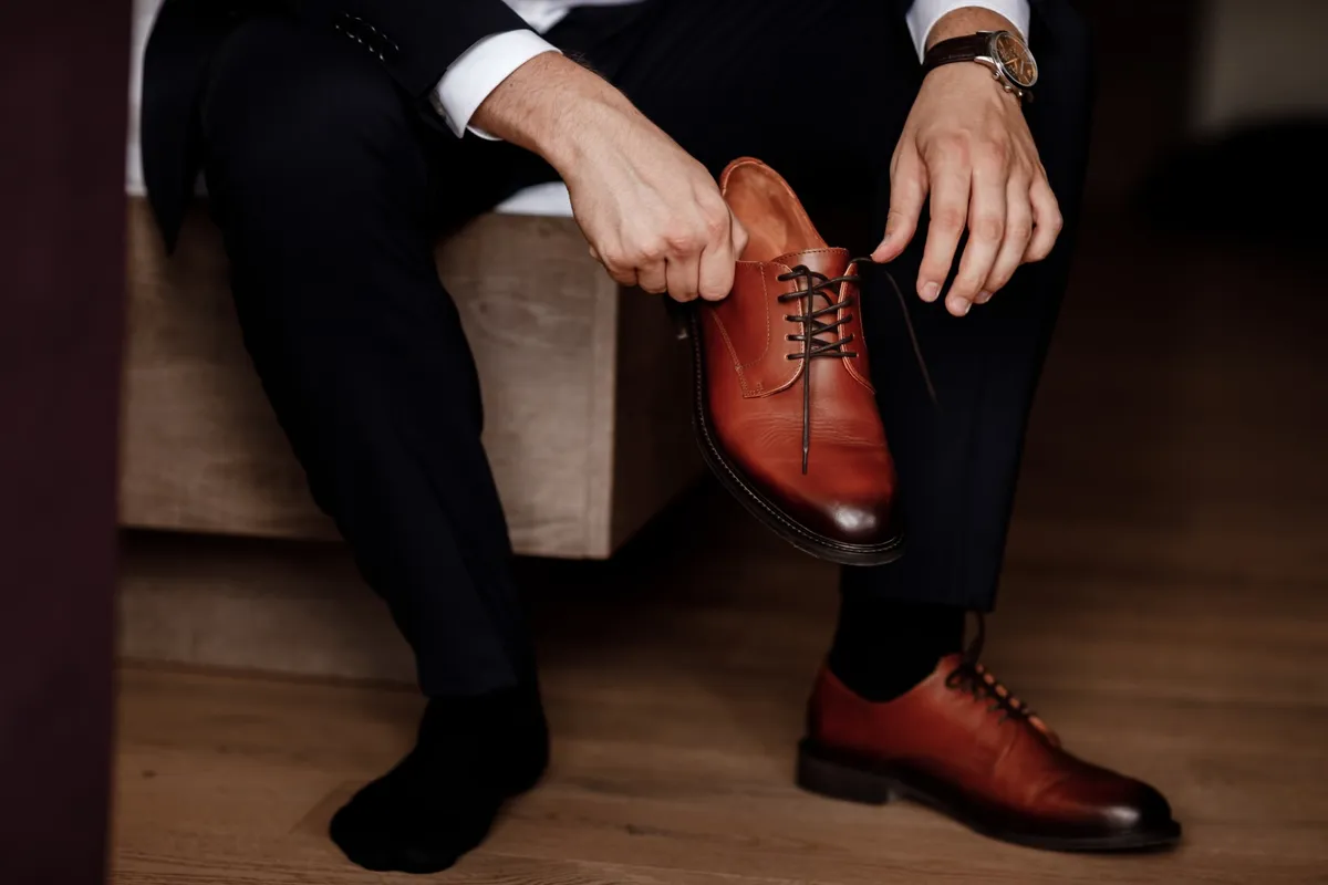 Businessman getting ready for work. Putting his shoes on. man puts on his brown shoes