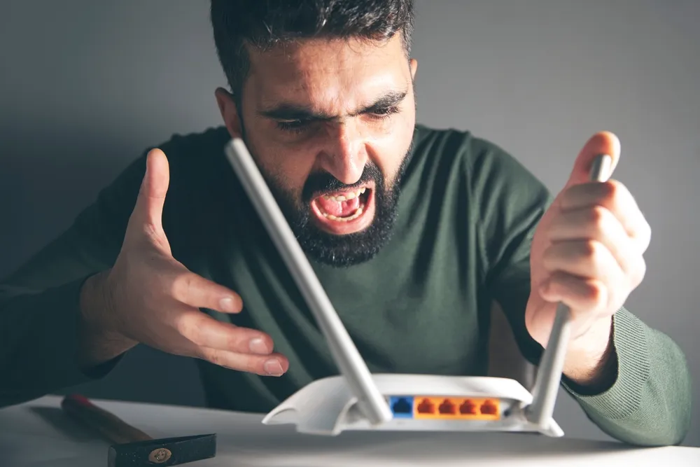 Férfi mérgelődik a wifi router miatt