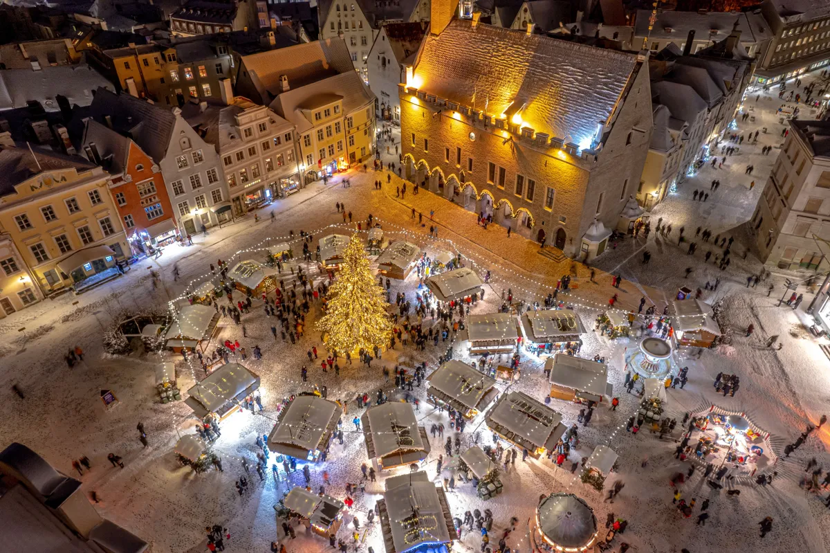 A tallni karácsonyi vásár légifelvételről behavazott térrel, templommal, karácsonyfával.