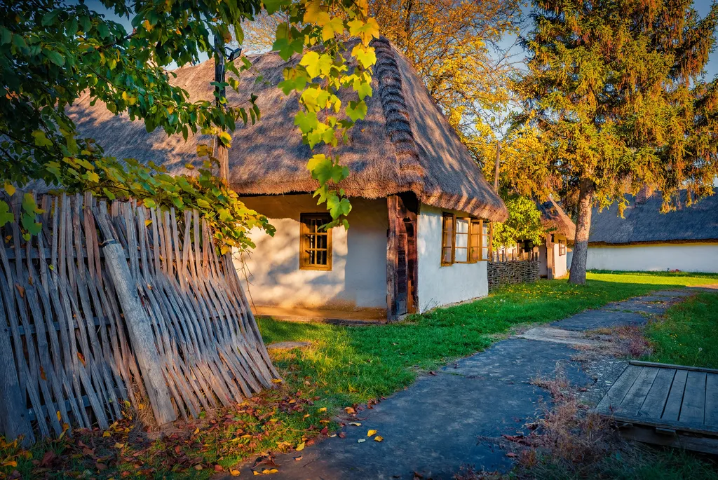 A Szombathely mellett található Vasi skanzen öreg házai aranyló őszi napfényben. 