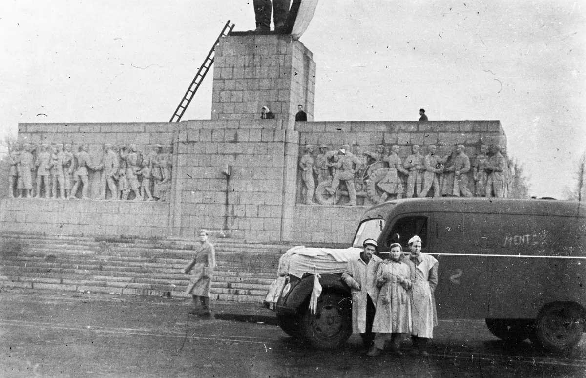 A ledöntött Sztálin szobor előtt egy mentőautó áll a mentős személyzettel 1956 októberében.