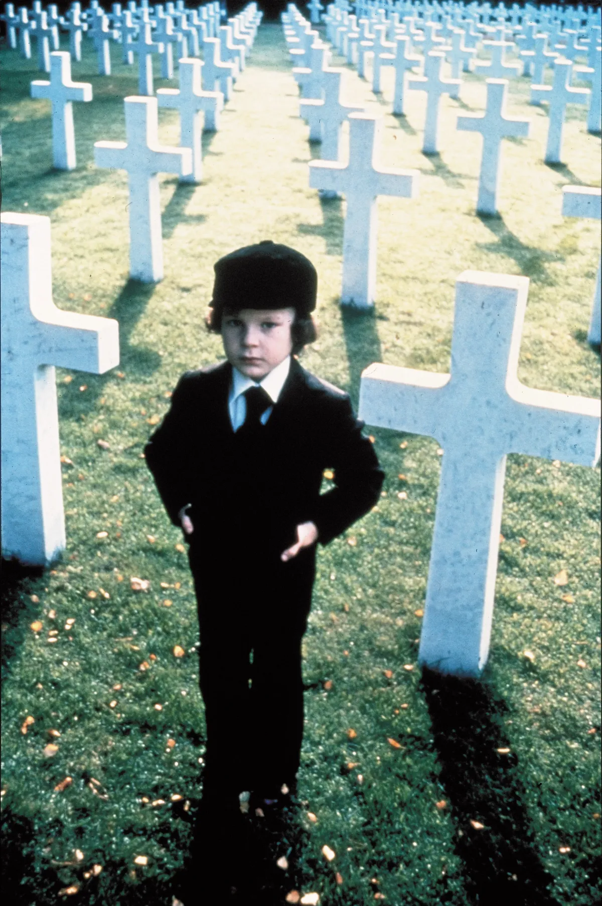 Részlet az Ómen című filmből: Damien fehér keresztek előtt áll.