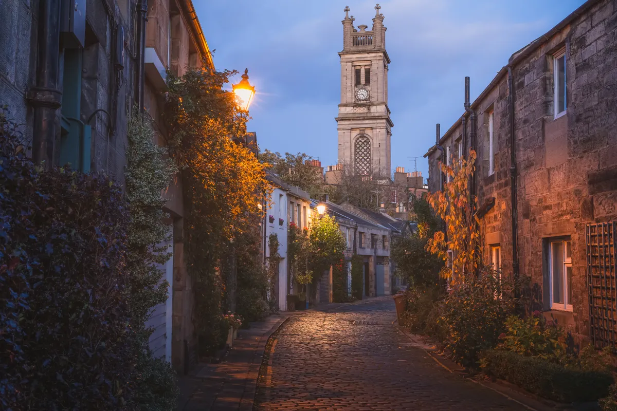Őszi városnézés Edinburgh macskaköves kis utcáin alkonyat után. 